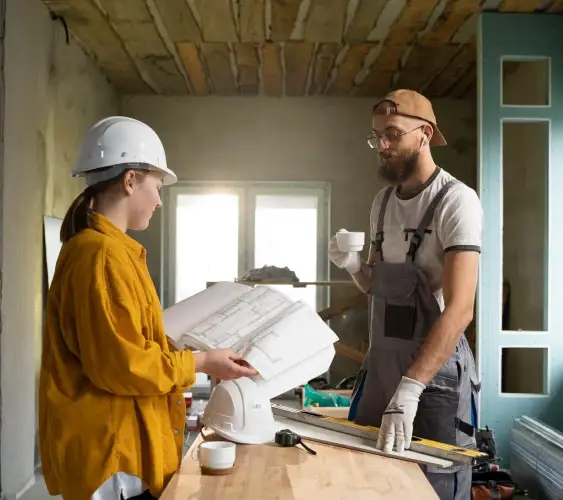 Two construction professionals reviewing blueprints during a dust-free demolition project by Demo Pros