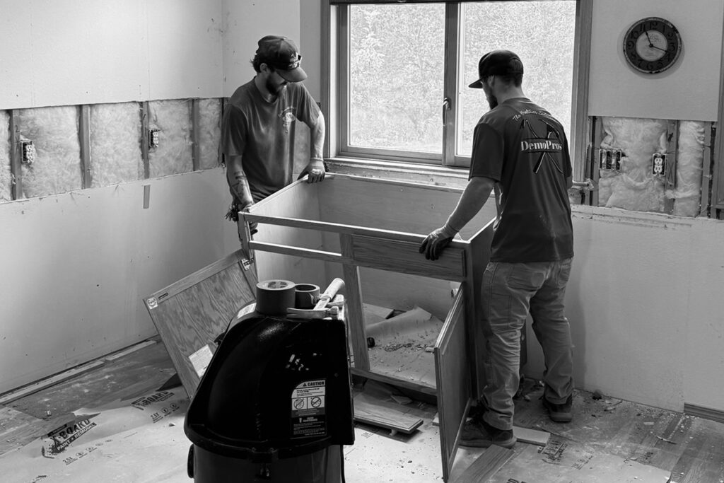 Two people demoing a cabinet from a kitchen